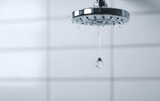 Close-up of water droplets on a chrome shower fixture