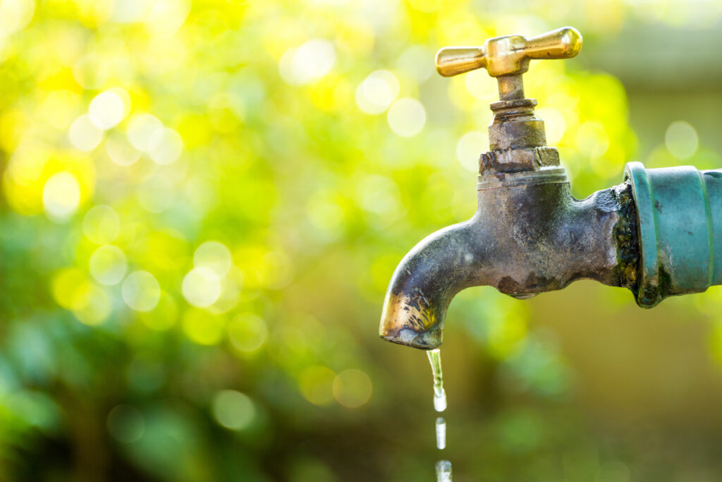 Brass water tap in nature background.